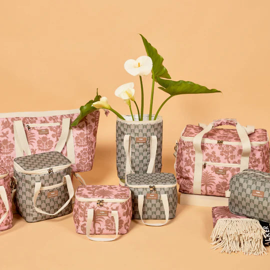 Set of floral-patterned bags on a beige background with a vase of flowers.