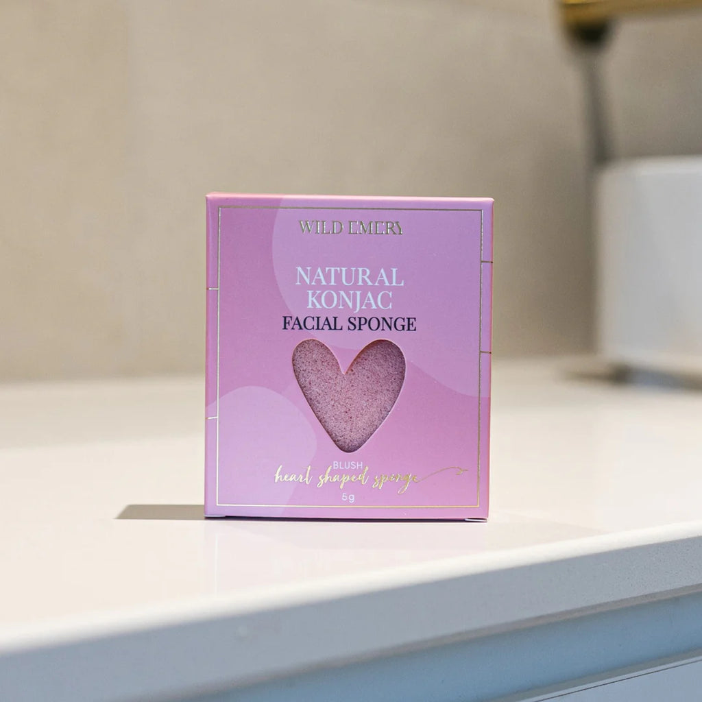 Pink packaging of a natural konjac facial sponge on a white surface