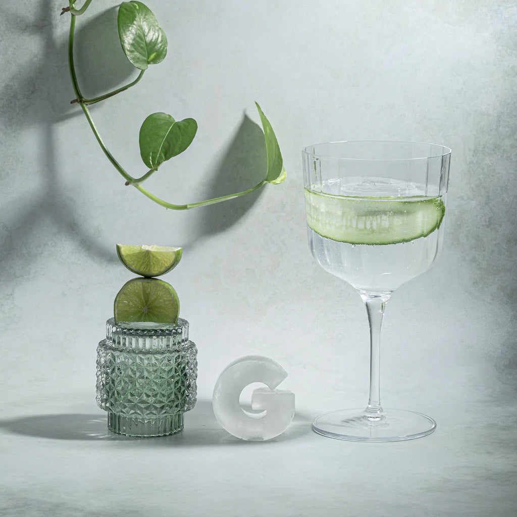 Cocktail glass with lime garnish on a textured surface