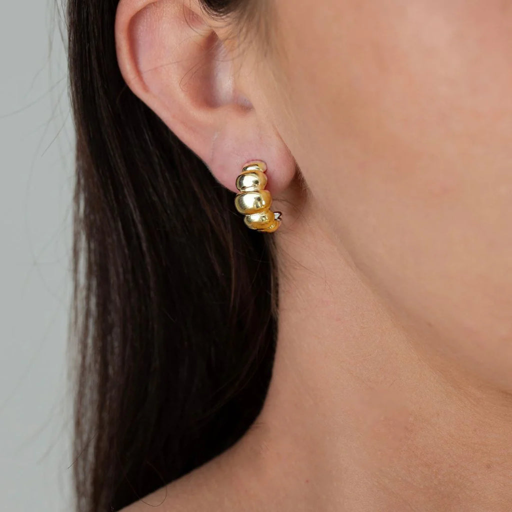 Close up of a person wearing a gold earring