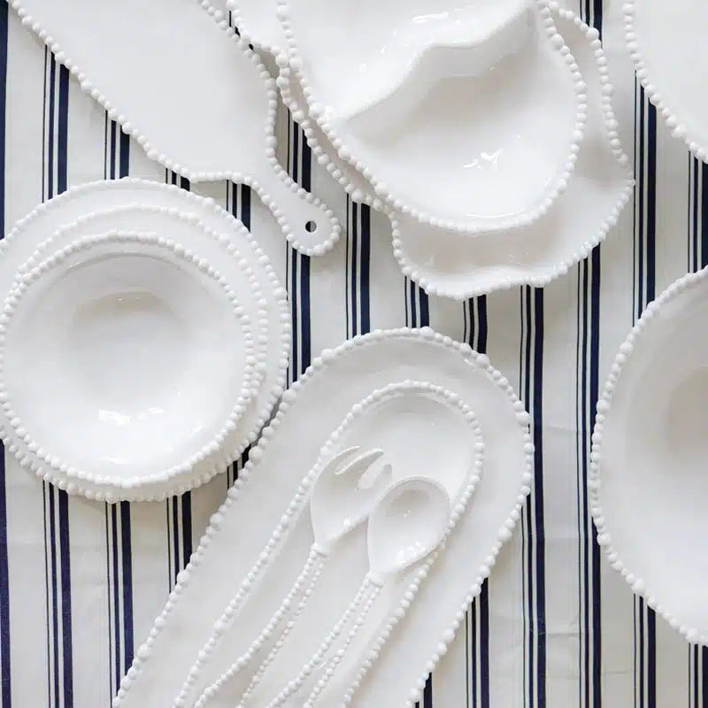 White ceramic bowls and spoons on a striped background