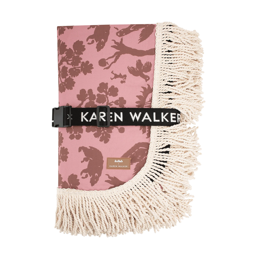 Pink floral blanket with beige fringe and 'Karen Walker' branding on a white background