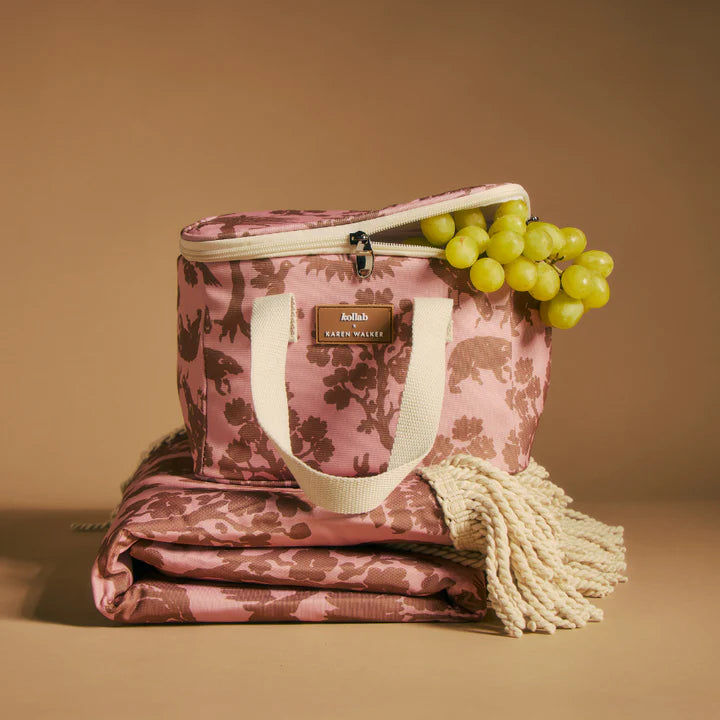 Pink floral-patterned bag with a tassel and grapes on a beige background