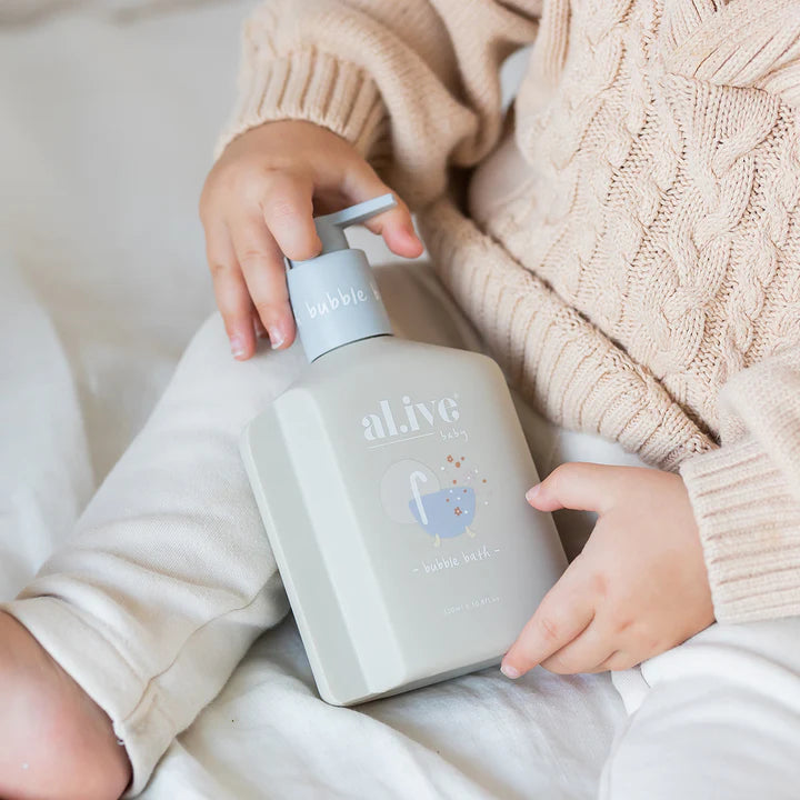 Person holding a bottle labeled 'alive' with a soft, neutral background