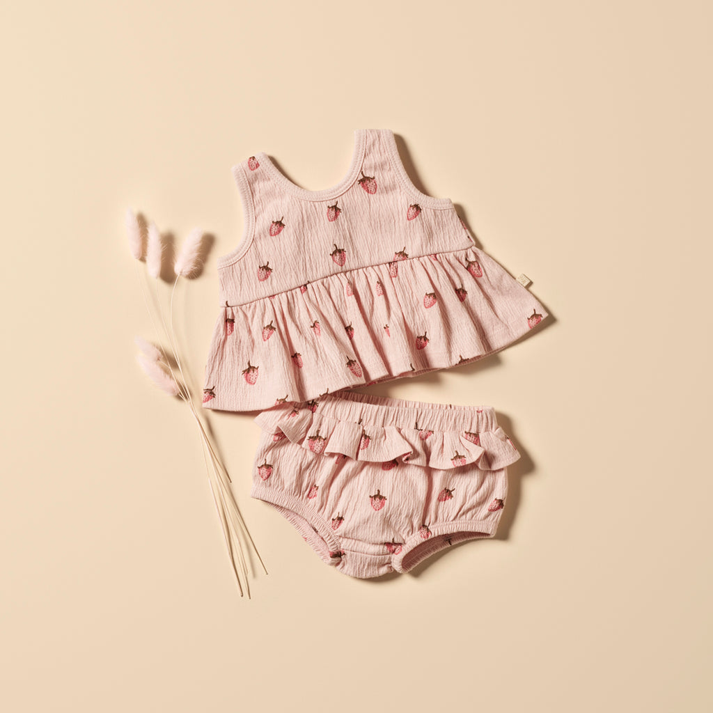 Baby dress and bloomers set with strawberry pattern on a beige background