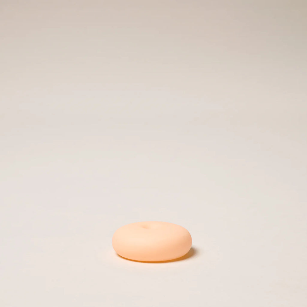 Small round peach-colored object on a light beige background