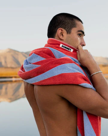 Man with a striped towel over his shoulder against a mountainous background