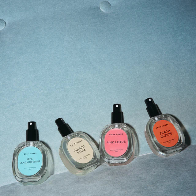 Four perfume bottles with labeled scents on a light blue background