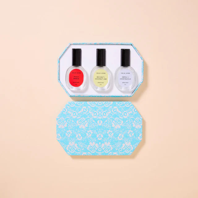 Set of three nail polish bottles in a decorative blue box on a beige background