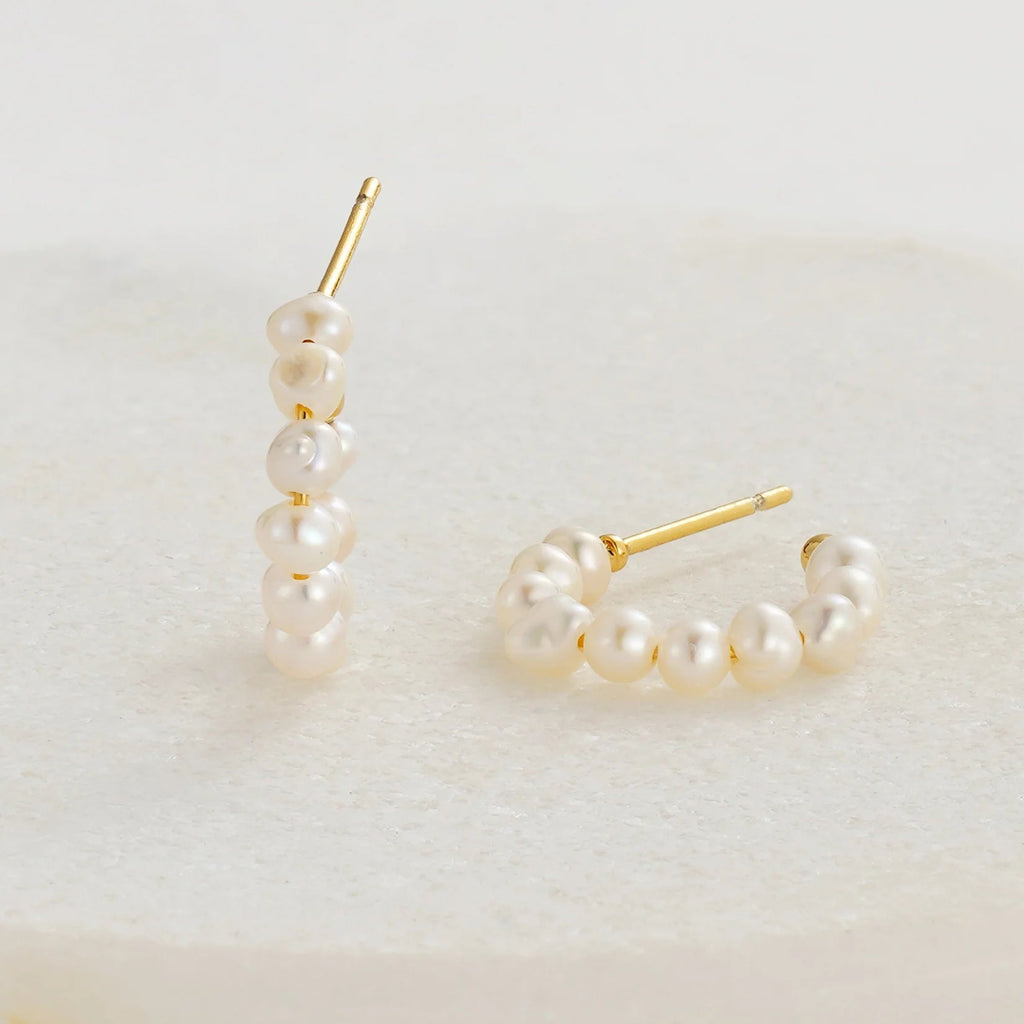 Pair of pearl hoop earrings on a light background