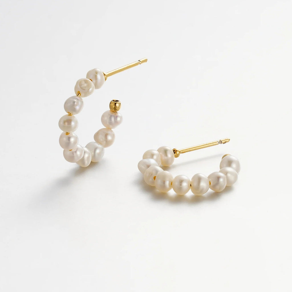 Pair of pearl hoop earrings on a white background