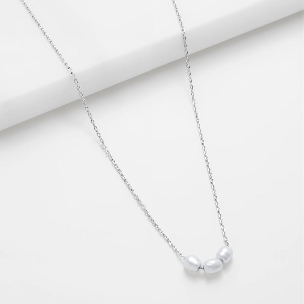 Silver necklace with a small pendant on a white background