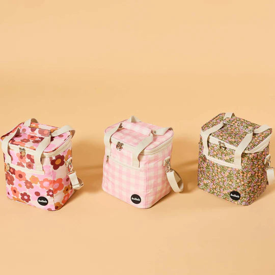 Three floral-patterned lunch bags on a beige background