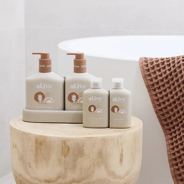 Set of 'alive' skincare products on a wooden stand with a towel in the background.