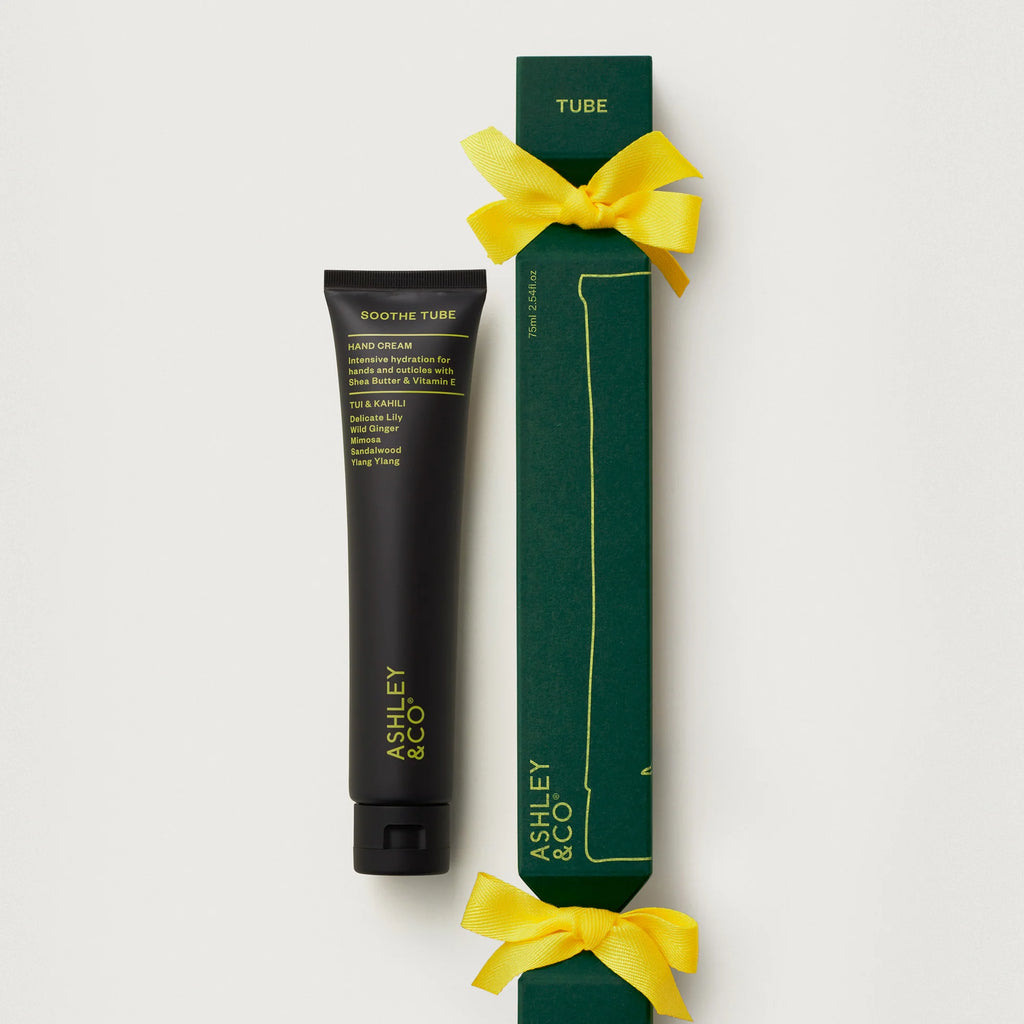 Tube of cream with green packaging and yellow ribbon on a white background