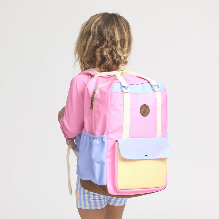 Person wearing a colorful backpack with a plain background