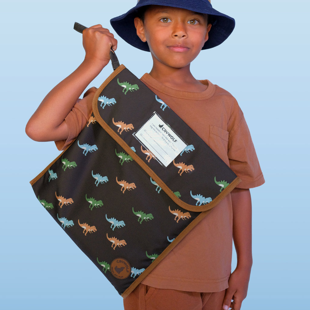 Child holding a dinosaur-patterned bag against a light blue background