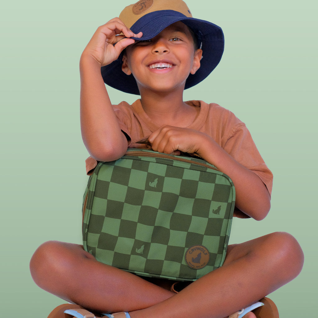Child holding a green checkered bag against a light green background