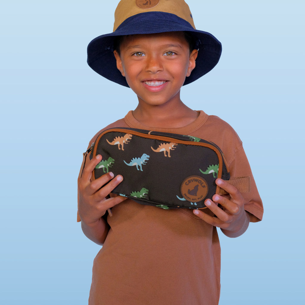 Child holding a dinosaur-patterned pouch against a light blue background