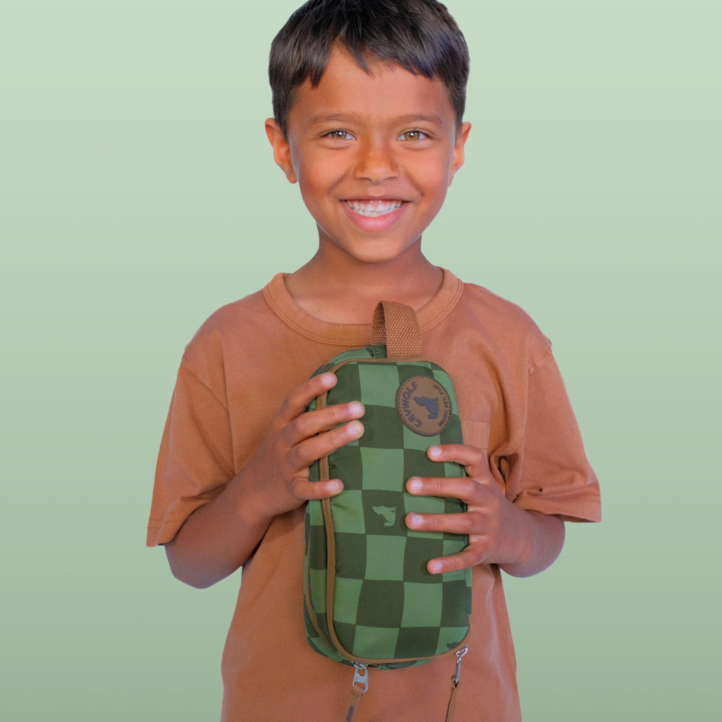 Child holding a green checkered bag against a light green background