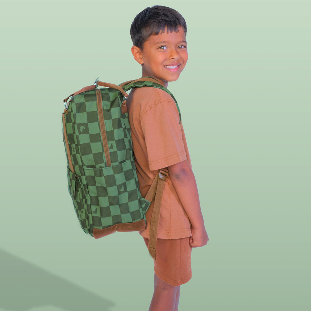 Child wearing a green checkered backpack on a light green background