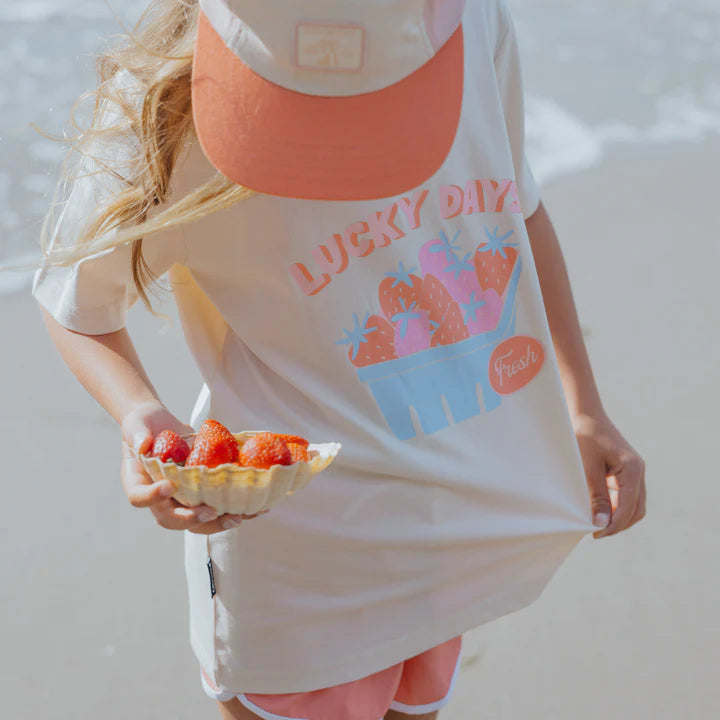 Person wearing a 'Lucky Dayz' t-shirt holding a plate of strawberries.