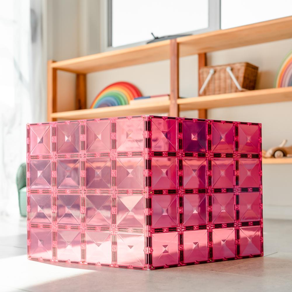 Pink geometric storage box on a surface with a blurred background