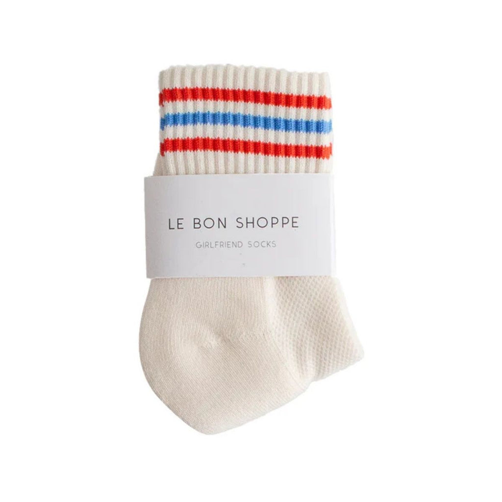 White sock with red and blue stripes on a white background, featuring 'Le Bon Shoppe' label.