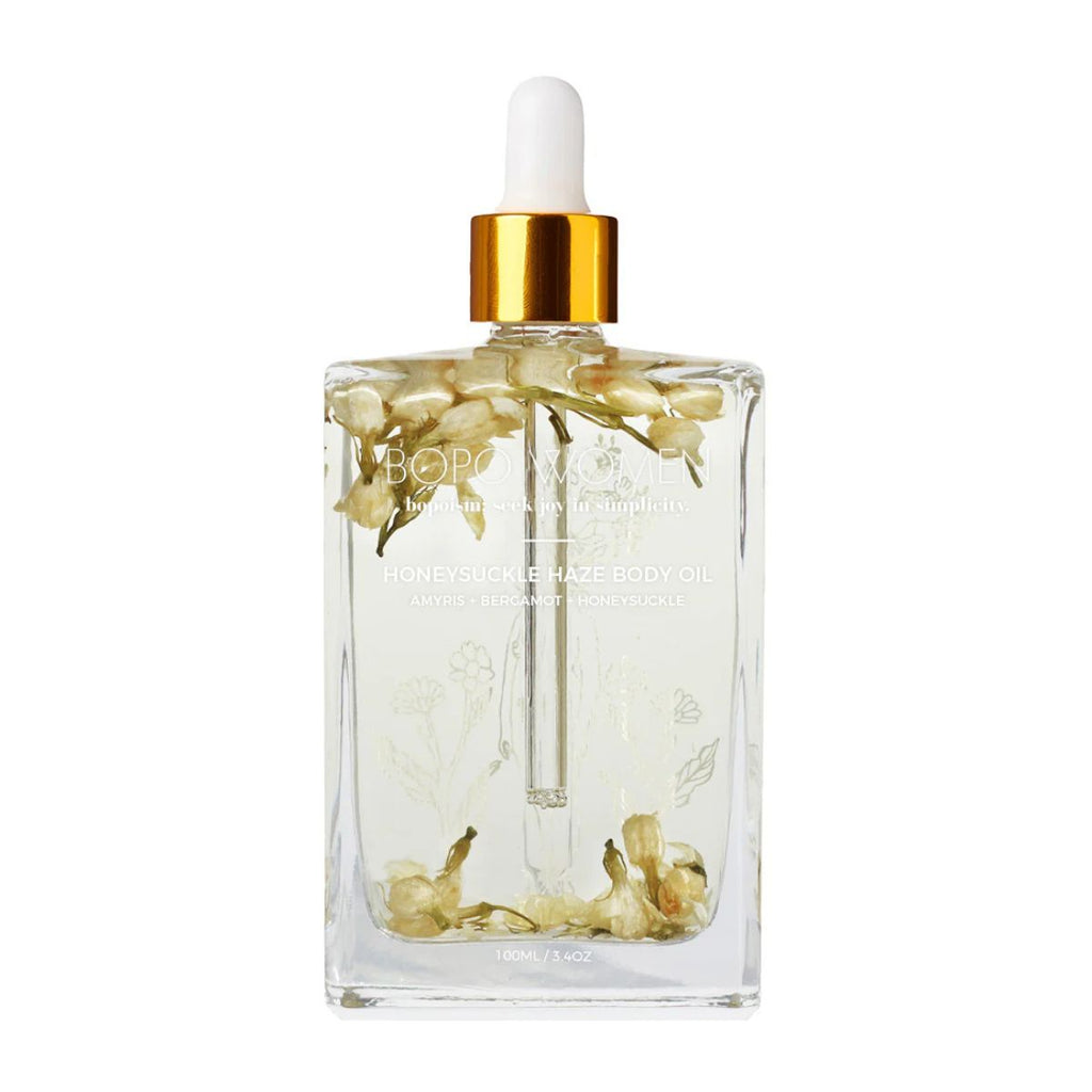 Clear bottle with floral design and gold cap on a white background