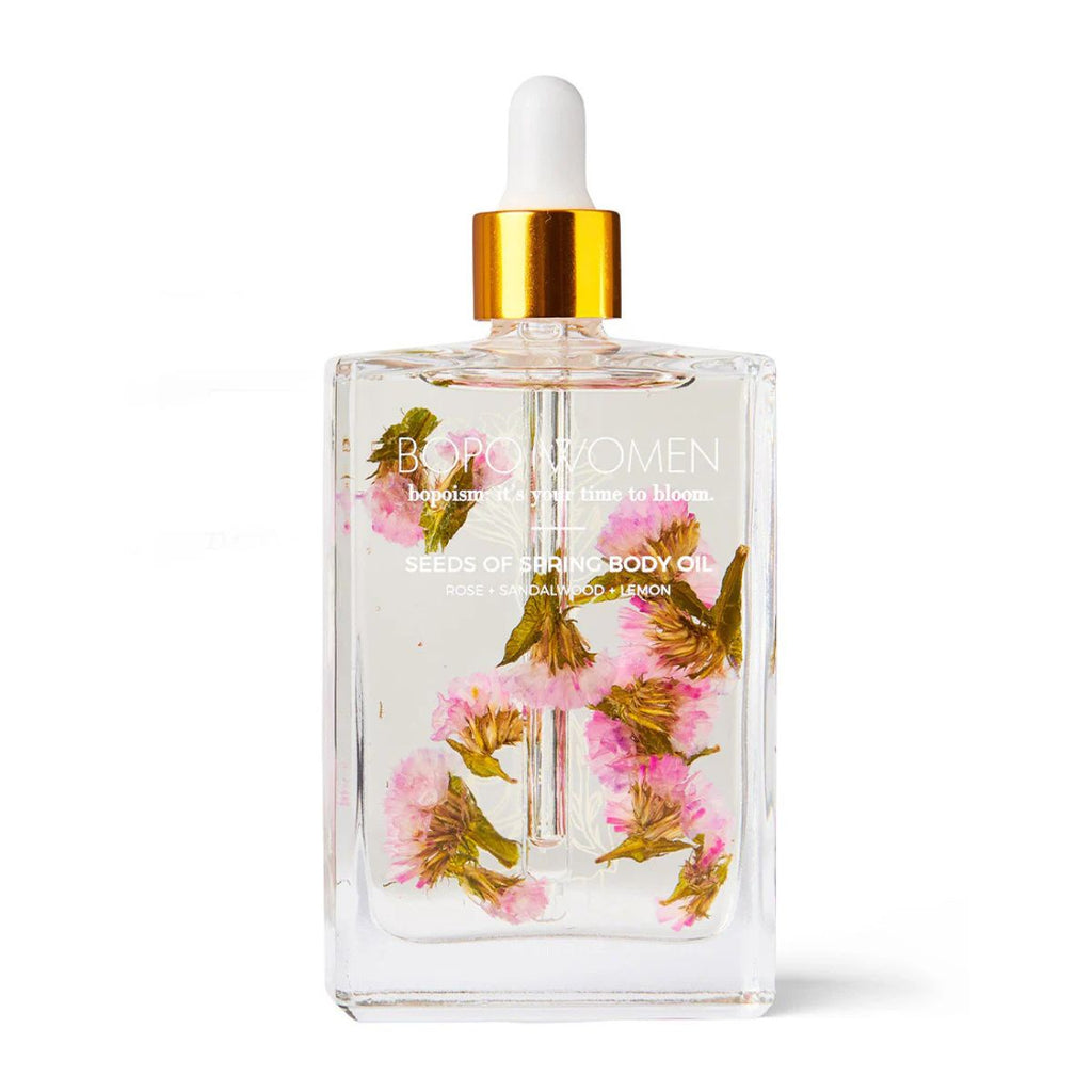 Clear bottle with floral design and gold cap on a white background