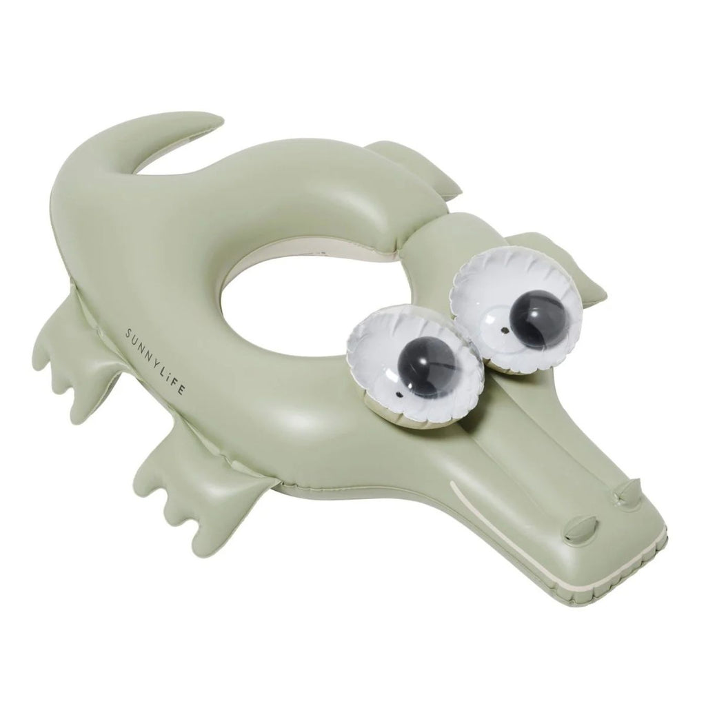 Inflatable crocodile pool toy with googly eyes on a white background