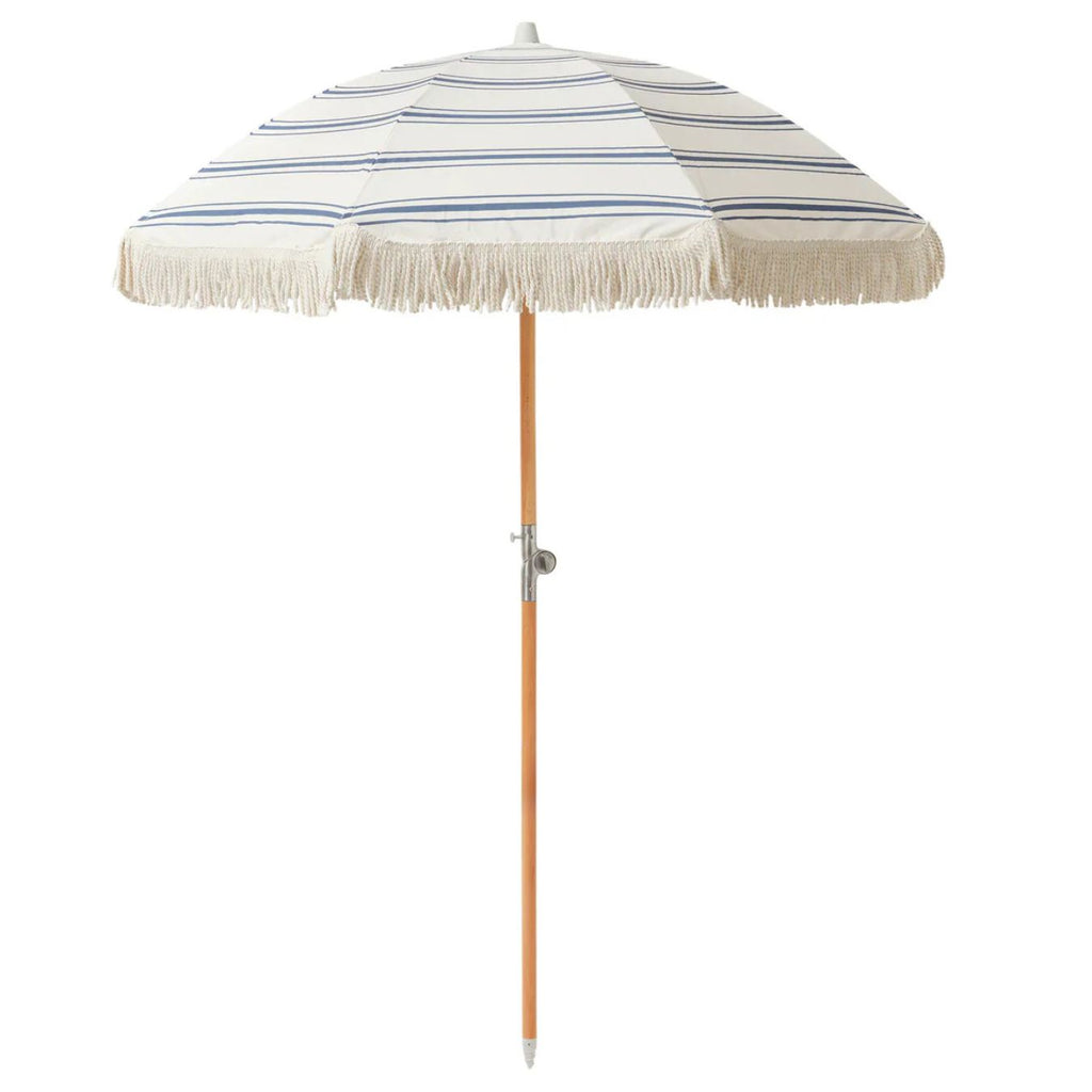 Striped beach umbrella with tassels on a white background