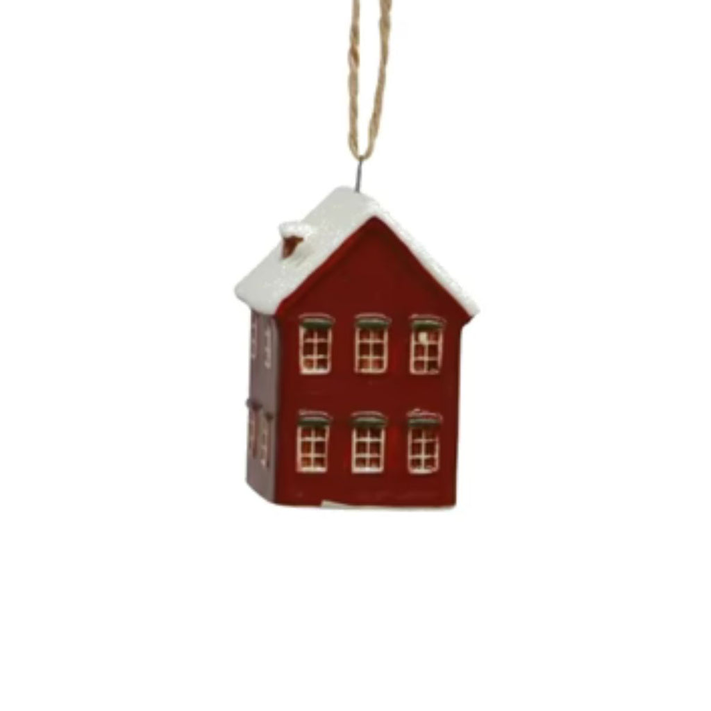 Red house-shaped ornament with white roof on a white background