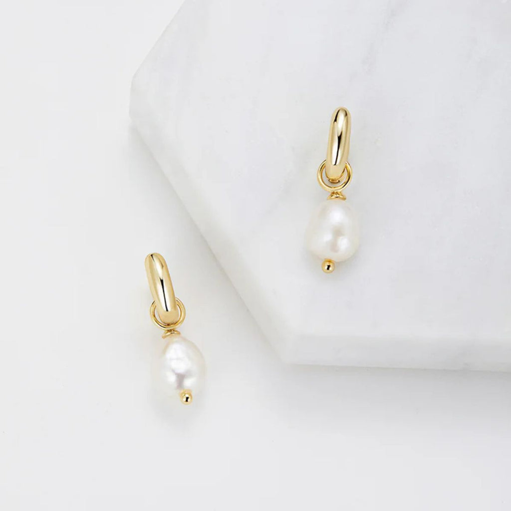 Gold earrings with pearls on a white background