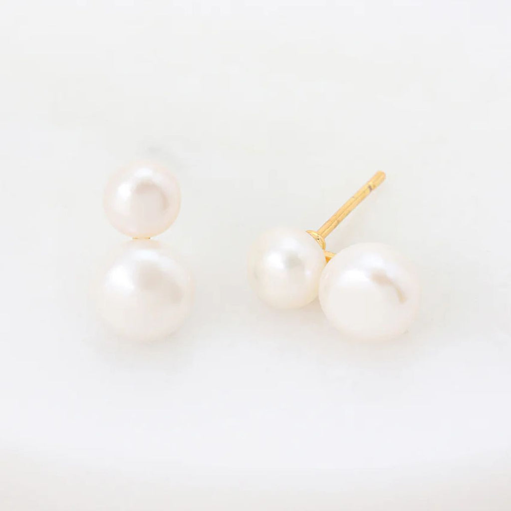 Pearl earrings on a light beige background