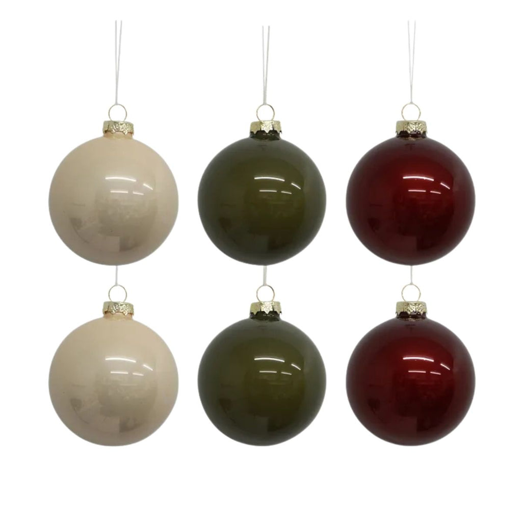 Set of six spherical ornaments in beige, green, and red on a white background