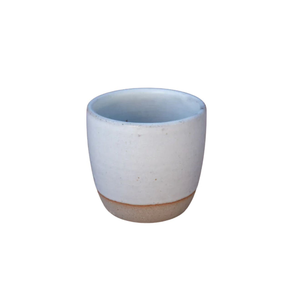 White ceramic cup with brown base on a white background