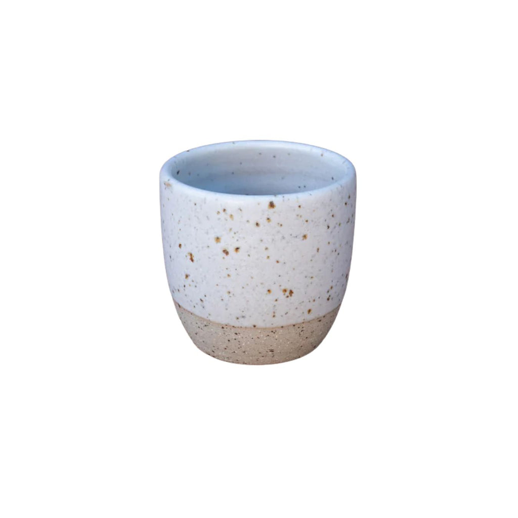 Speckled ceramic cup on a white background