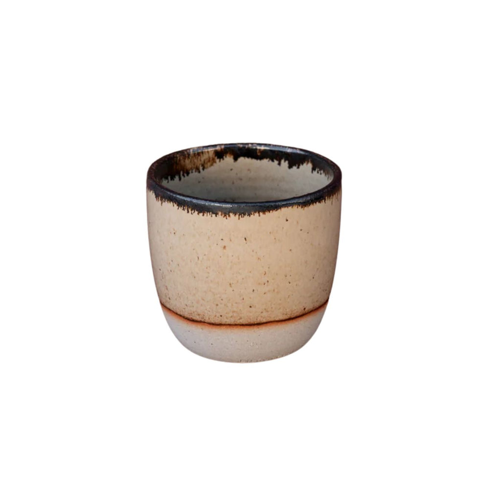 Ceramic cup with speckled beige and brown design on a white background