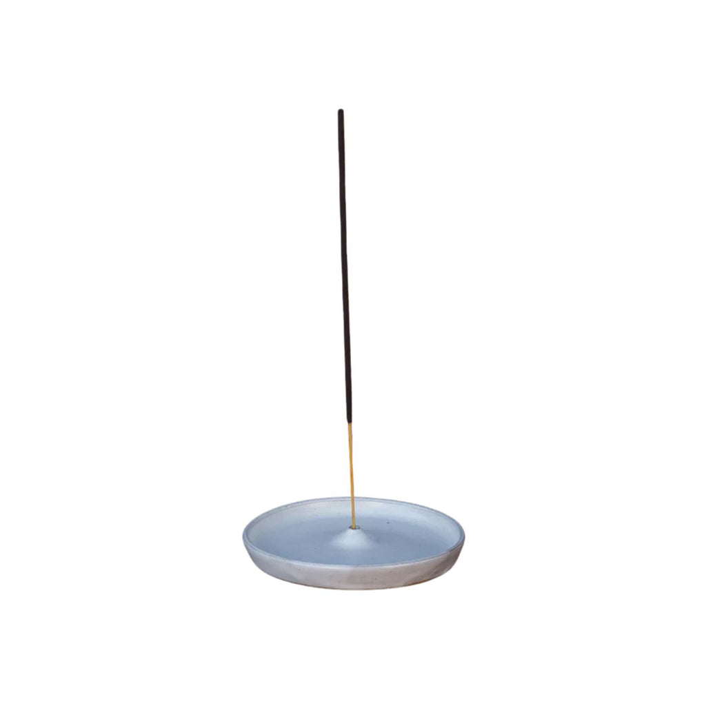 Ceramic incense holder with a single incense stick on a white background
