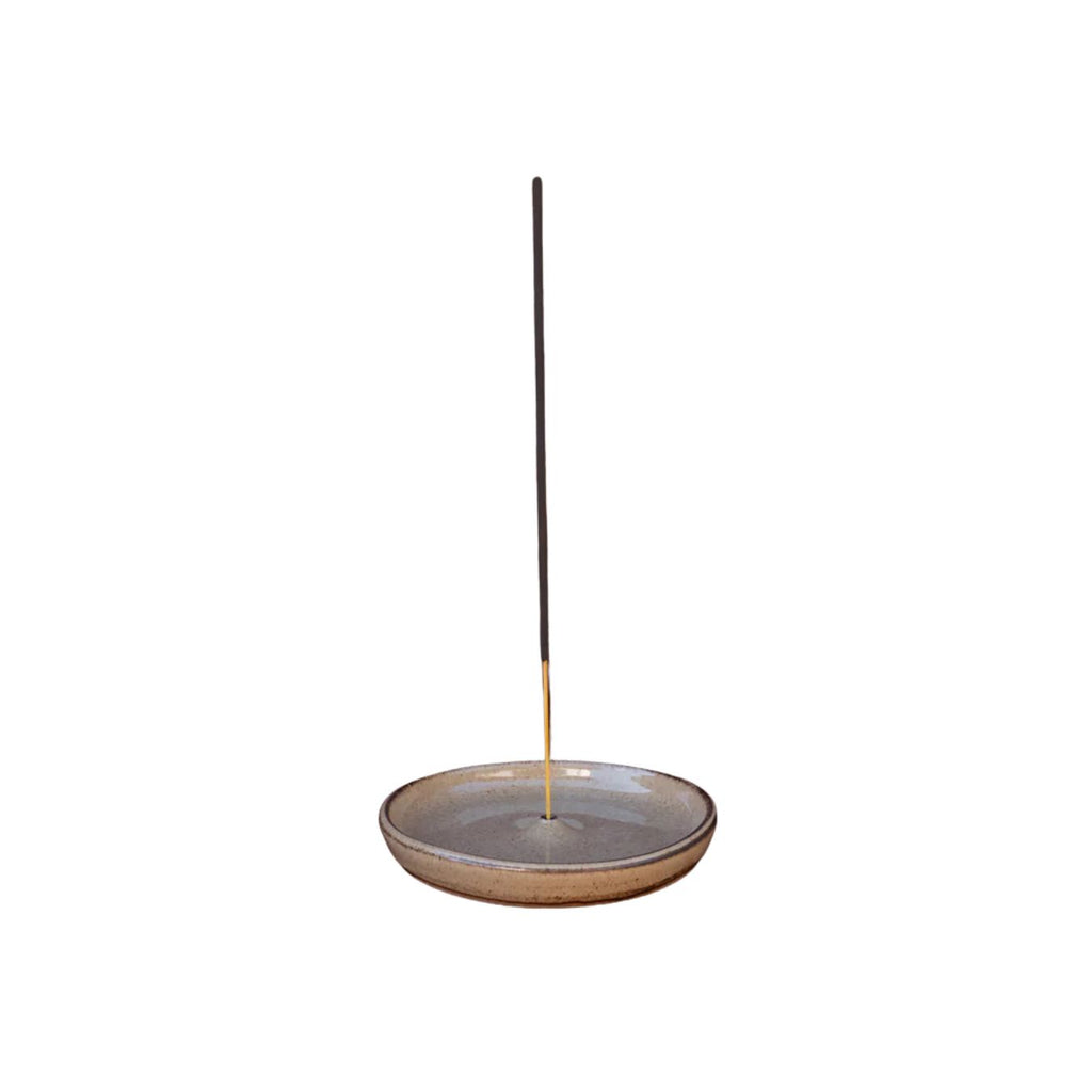 Ceramic incense holder with a single incense stick on a white background