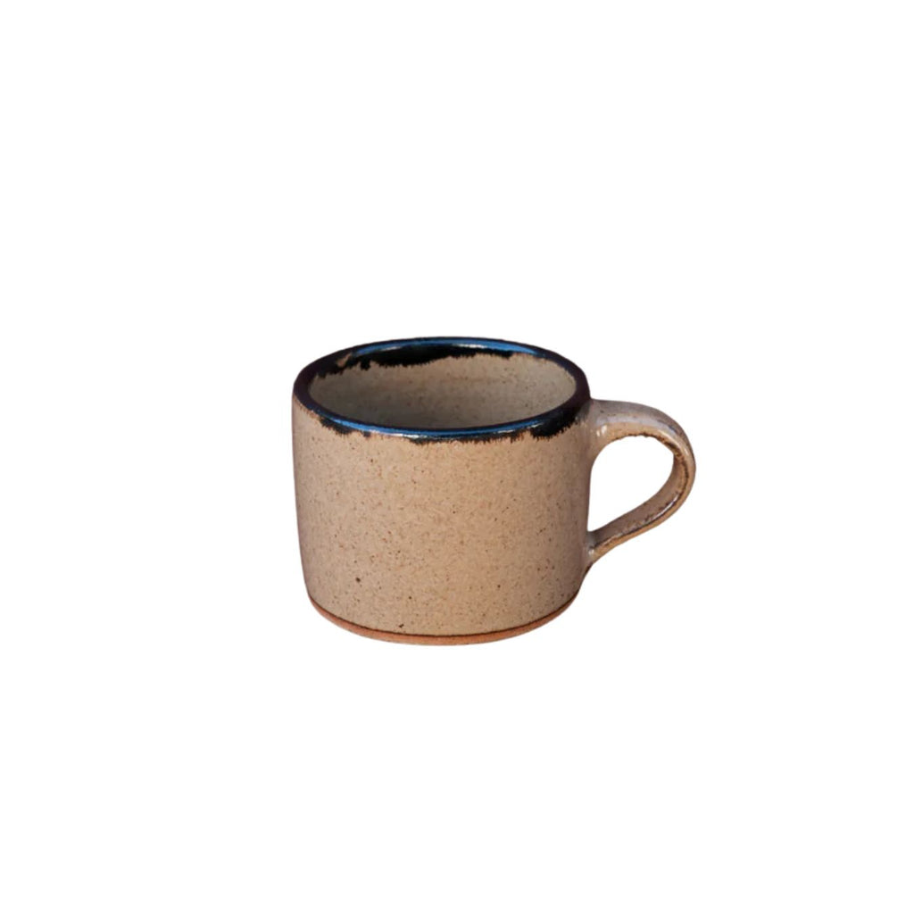 Beige ceramic mug with black interior on a white background