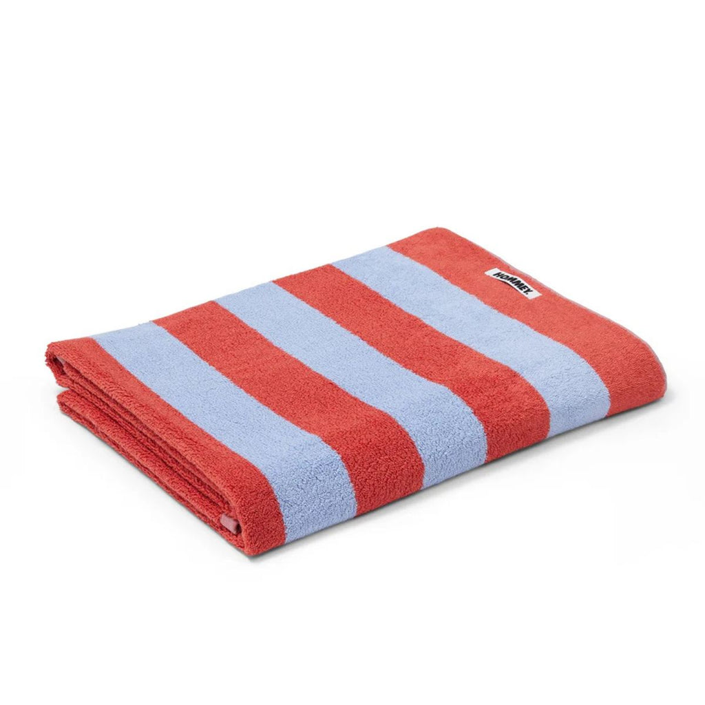 Folded red and light blue striped towel with a brand label on a white background