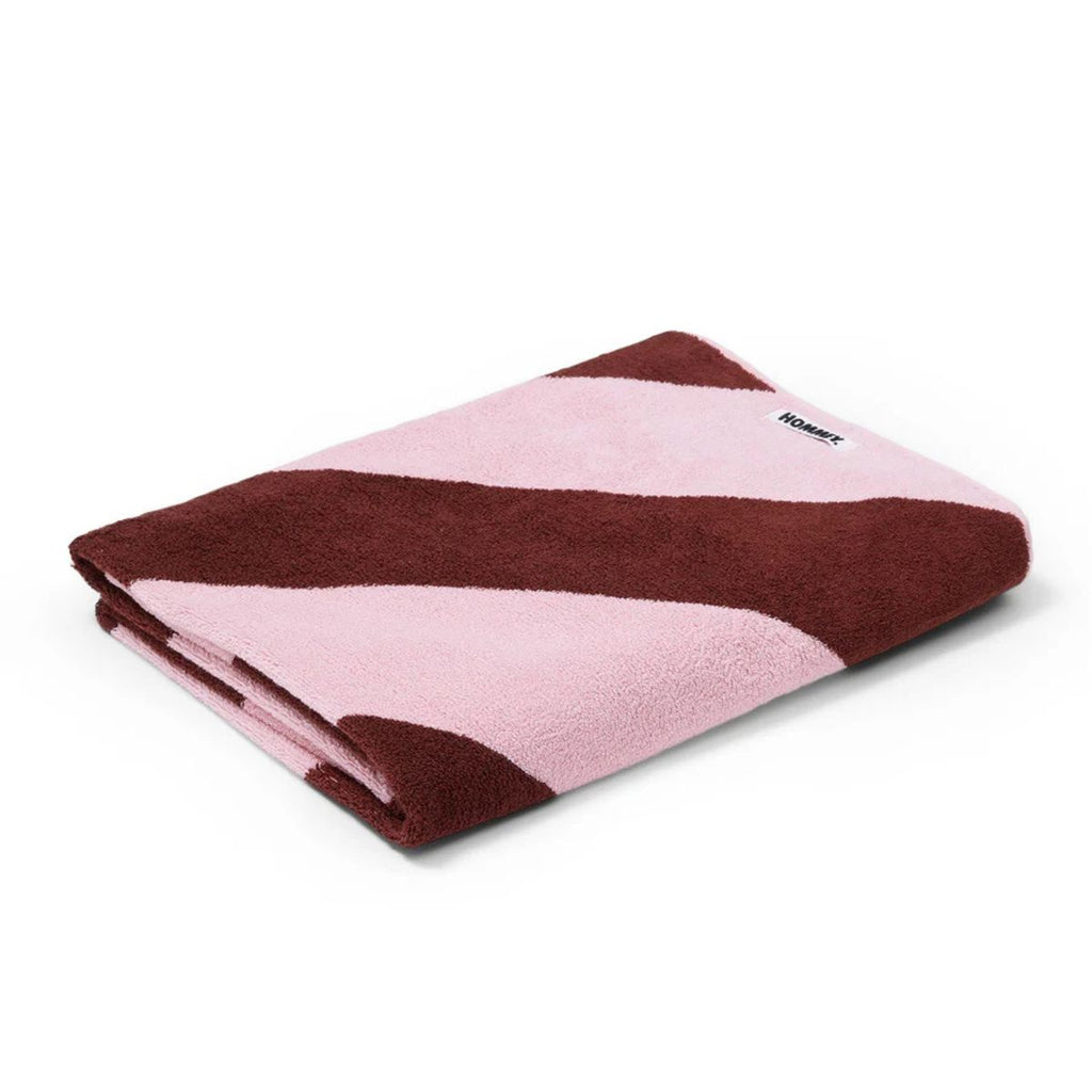 Folded pink and brown towel with a visible brand logo on a white background
