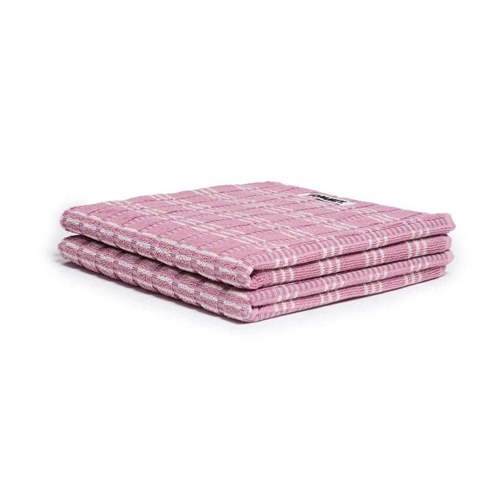 Stack of pink folded towels on a white background