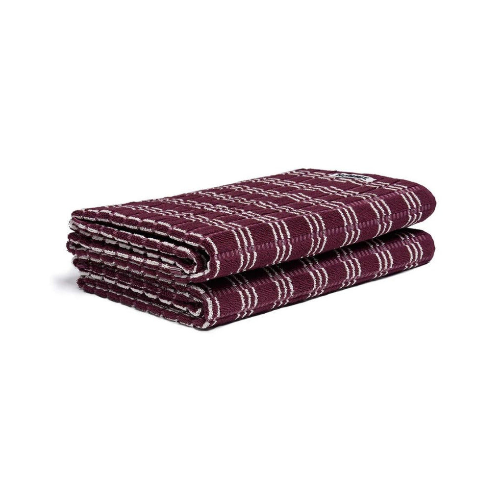 Folded purple and white striped towel on a white background