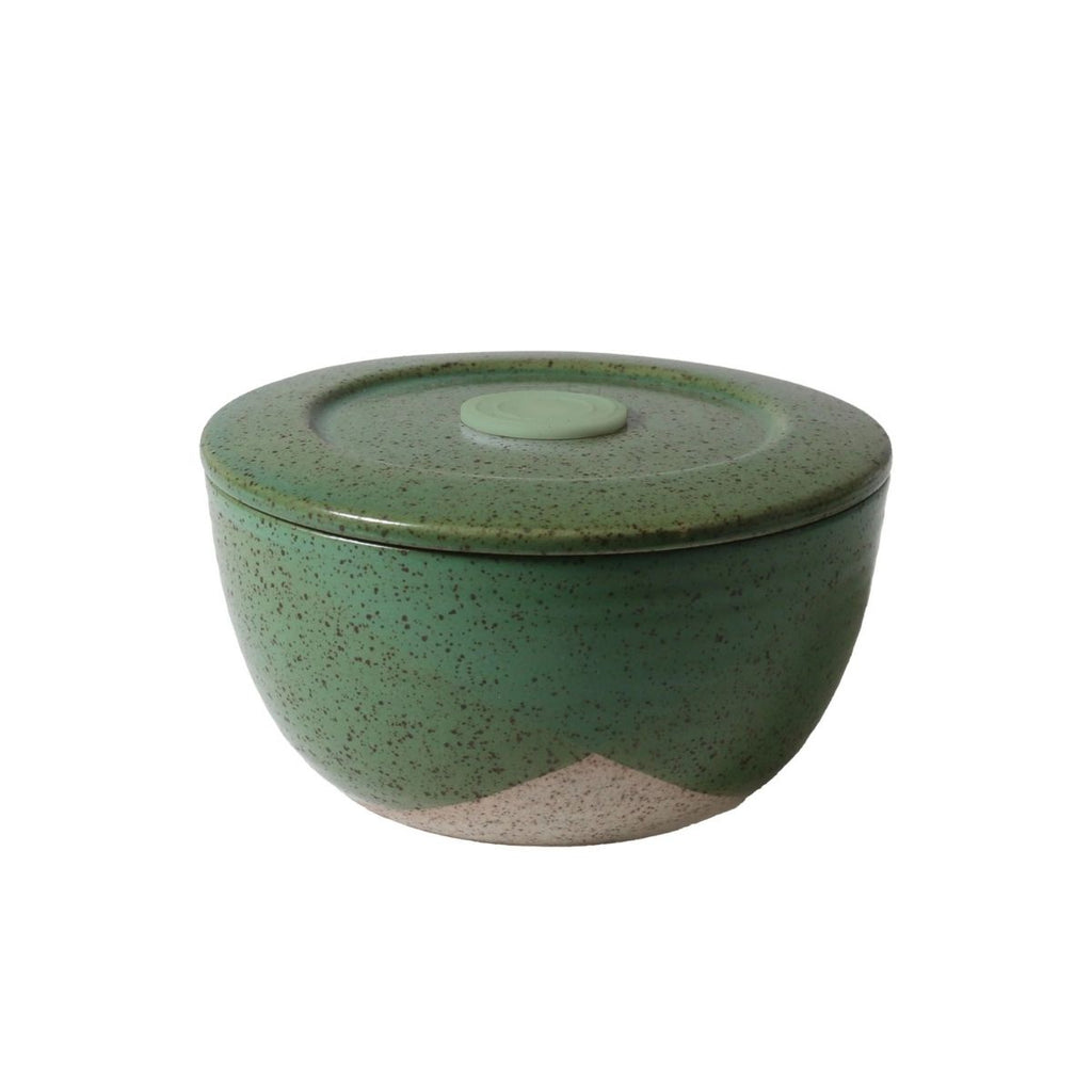Green ceramic container with a lid on a white background