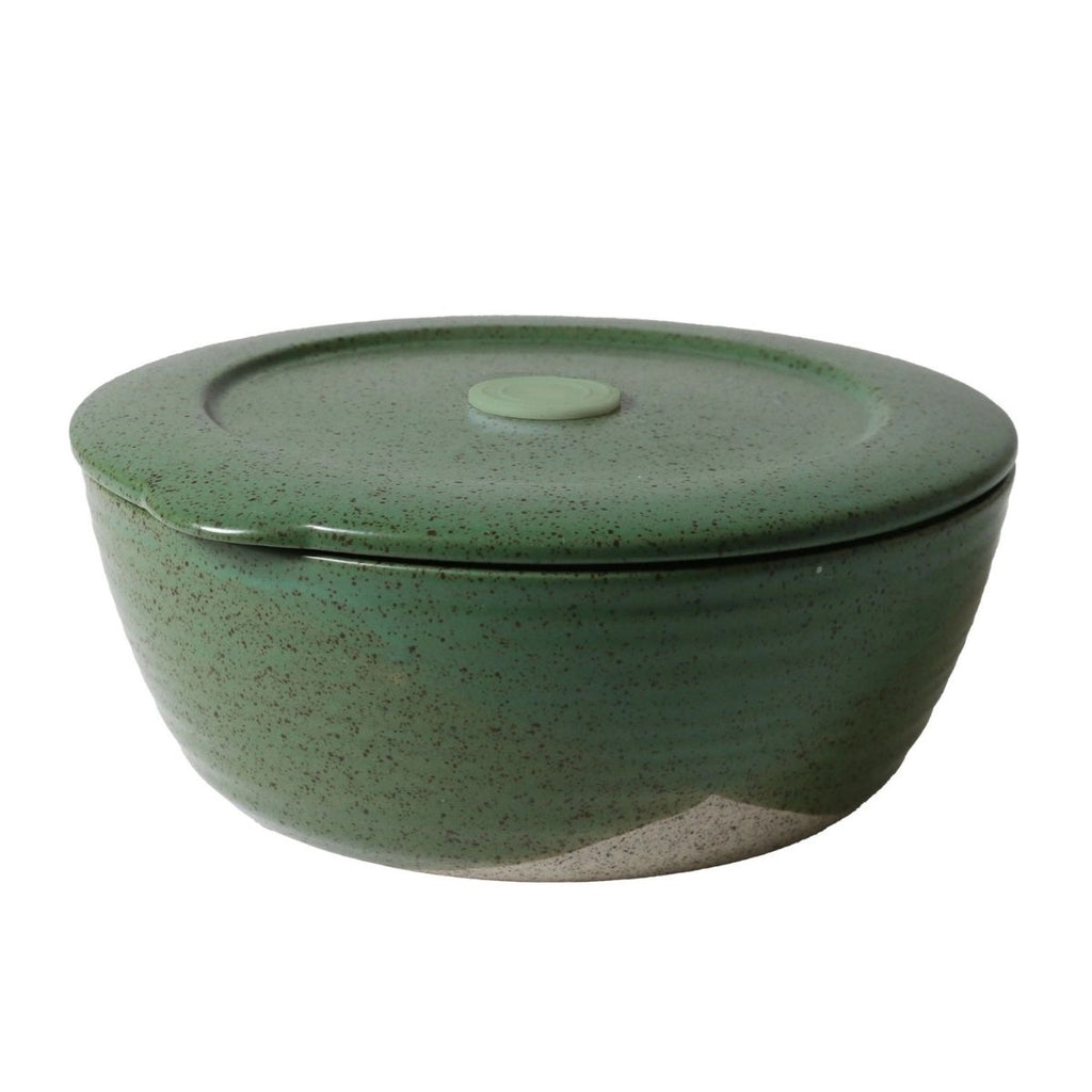 Green ceramic container with a lid on a white background