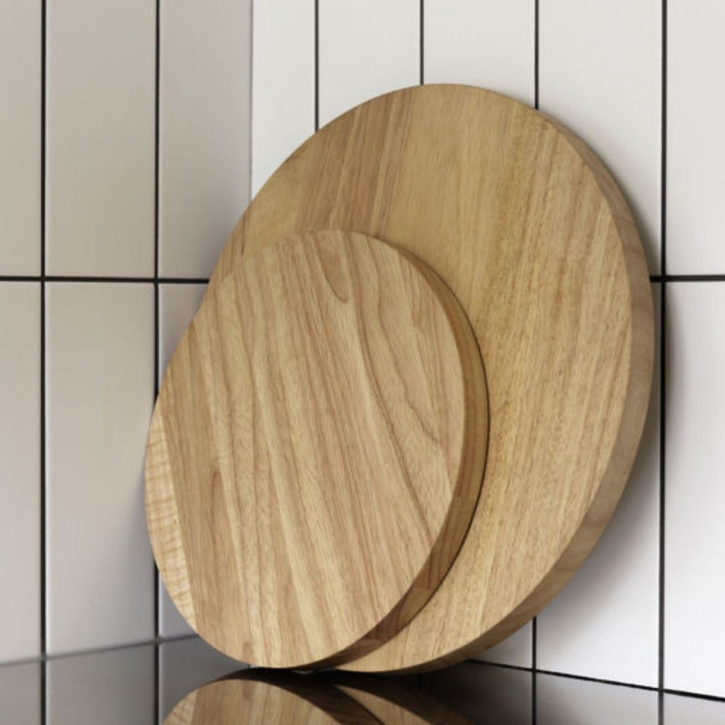 Two wooden cutting boards on a tiled floor