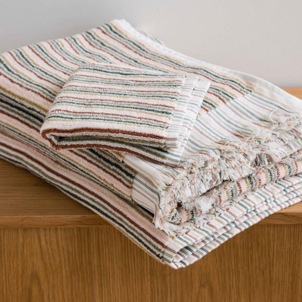 Striped fabric with tassels on a wooden surface
